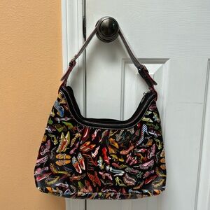 Sydney Love purse with multi color shoes on a black background